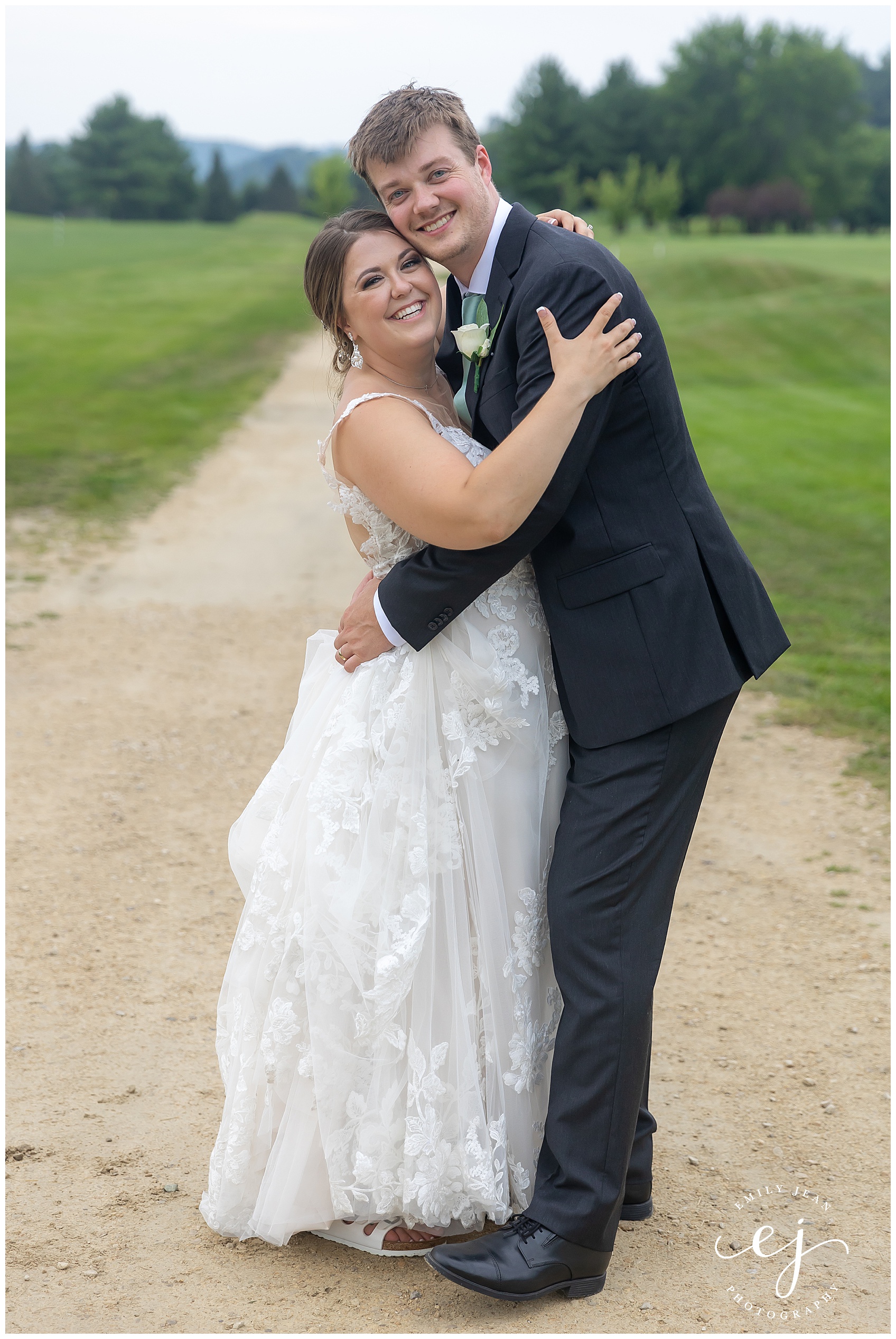 bride and groom hugging standing on golf course