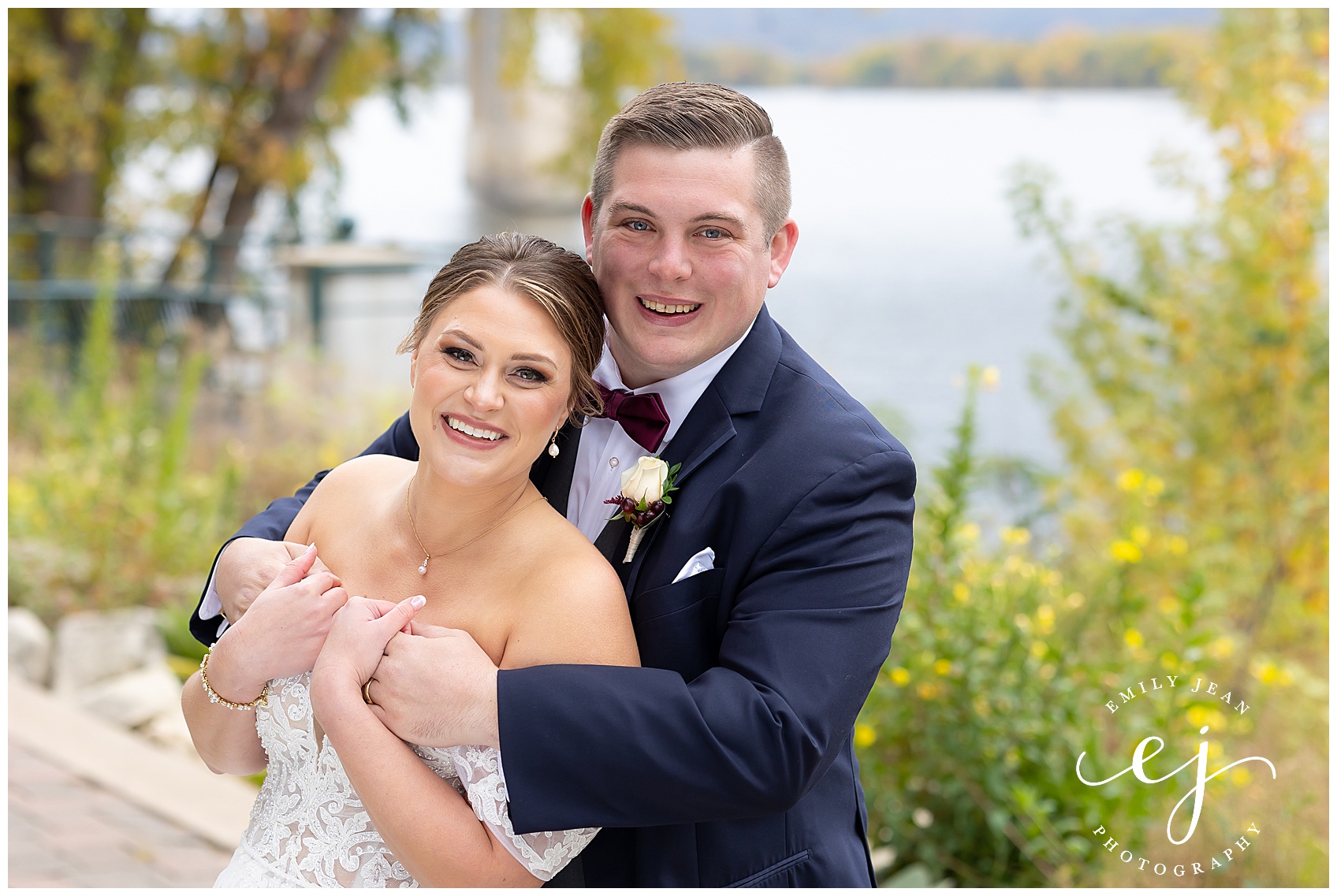 bride and groom smiling standing near the Mississippi river